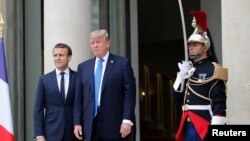 French President Emmanuel Macron greets U.S. President Donald Trump at the Elysee Palace in Paris, July 13, 2017.