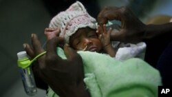 FILE - Three-day-old premature baby Jessica Thelusma is carried by her mother Silvie Estain in the emergency room at General Hospital in Port-au-Prince, Haiti.