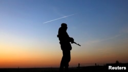 A Ukrainian soldier stands guard at a military camp on a field the Ukrainian Army forces set up close to the Russian border in east Ukraine March 21, 2014.