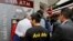 A man makes a transaction at an ATM outside a branch of Laiki Bank in Nicosia, March 21, 2013