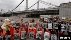 Greenpeace activists hold portraits of those detained on the boat Arctic Sunrise during a protest in Moscow, Russia, Oct. 5, 2013. 