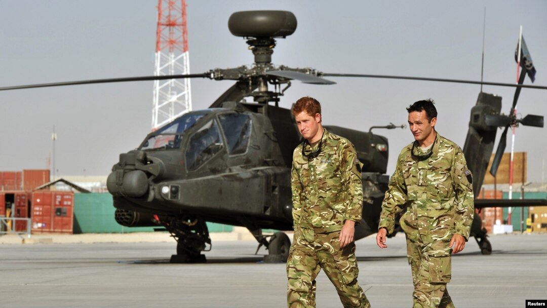Pangeran Harry berjalan melewati helikopter Apache di Camp Bastion, Afghanistan 7 September 2012. (Foto: REUTER/John Stillwell/POOL)