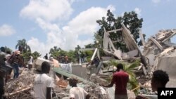 مردم در حال جستجو میان خرابه‌های یک هتل پس از زمین‌لرزه در شهر لس کیس در جنوب غرب هائیتی، شنبه ٢٣ مرداد ۱۴۰۰