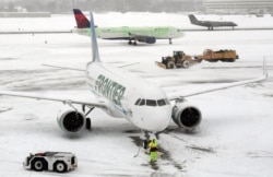 Ground crews remove snow from the airport tarmac as flights resume after an overnight snowfall, at the Albany International Airport in Colonie, N.Y., Dec. 2, 2019.
