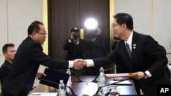 El viceministro de Unificación surcoreano, Chun Hae-Sung, right, saluda al líder de la negociación de Corea del Norte, Jon Jong Su durante la reunión en la zona de desmilitarización en Paju, Corea del Sur. 