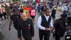 Hashim Nzinga, front left, a marcher who identified himself as national chairman of the New Black Panthers, marches with others in Charleston, to the Emanuel AME Church, six days after a gunman shot nine people inside the building, June 23, 2015.