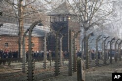 In this file photo taken Jan. 27, 2020, people are seen arriving at the site of the Auschwitz-Birkenau Nazi German death camp in Oswiecim, Poland, for observances marking 75 years since the camp's liberation by the Soviet army. (AP Photo/Czarek Sokolowski)