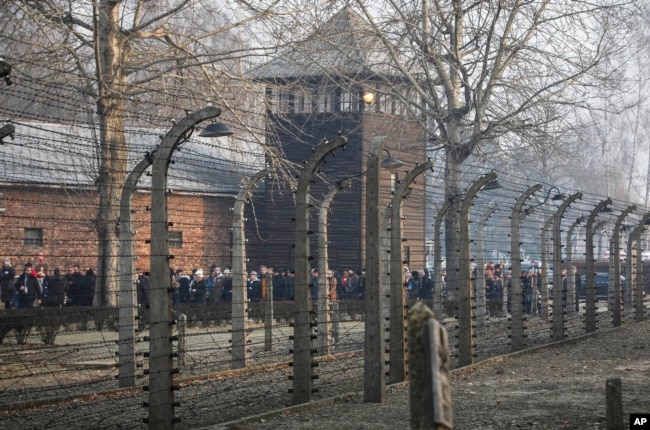 In this file photo taken Jan. 27, 2020, people are seen arriving at the site of the Auschwitz-Birkenau Nazi German death camp in Oswiecim, Poland, for observances marking 75 years since the camp's liberation by the Soviet army. (AP Photo/Czarek Sokolowski)
