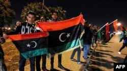 Des Libyens brandissent le drapeau national lors de la célébration du septième anniversaire de la chute de Moammar Kadhafi, à Benghazi, dans l'est du pays, le 17 février 2017