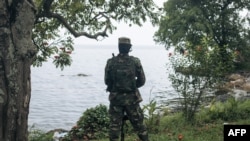 Um combatente do M23 monta guarda durante uma conferência de imprensa na província de Kivu do Norte, em Goma, a 6 de fevereiro de 2025, após uma reunião pública convocada pelo grupo armado.