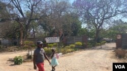 Children walks past the gate of school closed in Harare on September 22, 2020 (C. Mavhunga/VOA)