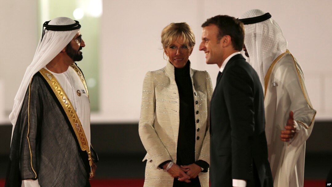 Presiden Perancis Emmanuel Macron dan Ibu Negara, Brigitte, disambut penguasa Dubai, Sheikh Mohammed bin Rashid Al Maktoum, kiri, dan Putera Mahkota Abu Dhabi Mohammed bin Zayed al-Nahayan, kanan, pada peresmian pembukaan Museum Louvre Dubai, 8 November 2017.