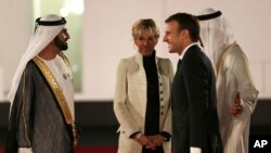 Presiden Perancis Emmanuel Macron dan Ibu Negara, Brigitte, disambut penguasa Dubai, Sheikh Mohammed bin Rashid Al Maktoum, kiri, dan Putera Mahkota Abu Dhabi Mohammed bin Zayed al-Nahayan, kanan, pada peresmian pembukaan Museum Louvre Dubai, 8 November 2017.