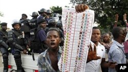 Supporters of oppositions candidate Etienne Tshisekedi parade what they claim are badly printed photocopies of election ballots they say they found in the Bandal commune in Kinshasa, Democratic Republic of Congo, November 28, 2011.