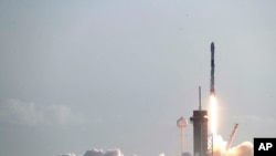 FILE - A Falcon 9 SpaceX rocket with a payload of approximately 60 satellites for SpaceX's Starlink broadband network lifts off from pad 39A at the Kennedy Space Center in Cape Canaveral, Fla., March 18, 2020.