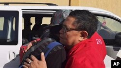 A Filipino worker embraces a staff of the department as they are evacuated from Tripoli, Libya, April 17, 2019.