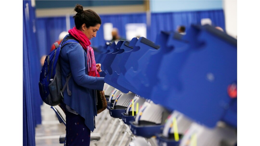FILE - A young voter casts her ballot during early voting in Chicago, Illinois, Oct. 14, 2016.
