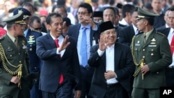 Indonesia's President Joko Widodo walks with his Vice President Jusuf Kalla in Jakarta, Indonesia, Oct. 20, 2014.