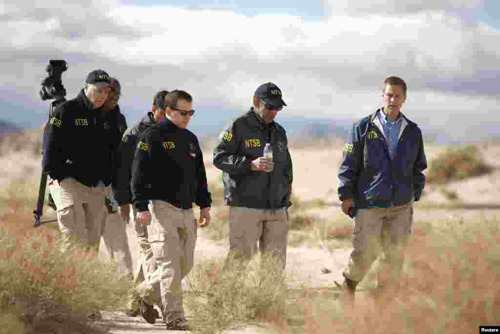 Investigators from the National Transportation Safety Board (NTSB) walk through one of the debris fields from the crash of Virgin Galactic's SpaceShipTwo near Cantil, California, Nov. 1, 2014. 