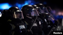 FILE - Police officers stand in the line in riot gear during protests against police brutality, in Minneapolis, Minnesota, May 28, 2020.
