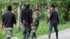 ARCHIVO - Rebeldes de las Fuerzas Armadas Revolucionarias de Colombia (FARC) abandonan el área después de bloquear una carretera en El Palo, en el estado sureño de Cauca, Colombia, el martes 4 de junio de 2013.