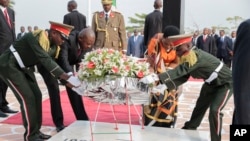 FILE - Burundian President Pierre Nkurunziza, second left, lays a wreath on grave of the independence hero Prince Louis Rwagasore, in Bujumbura, Burundi, July 1, 2015. 