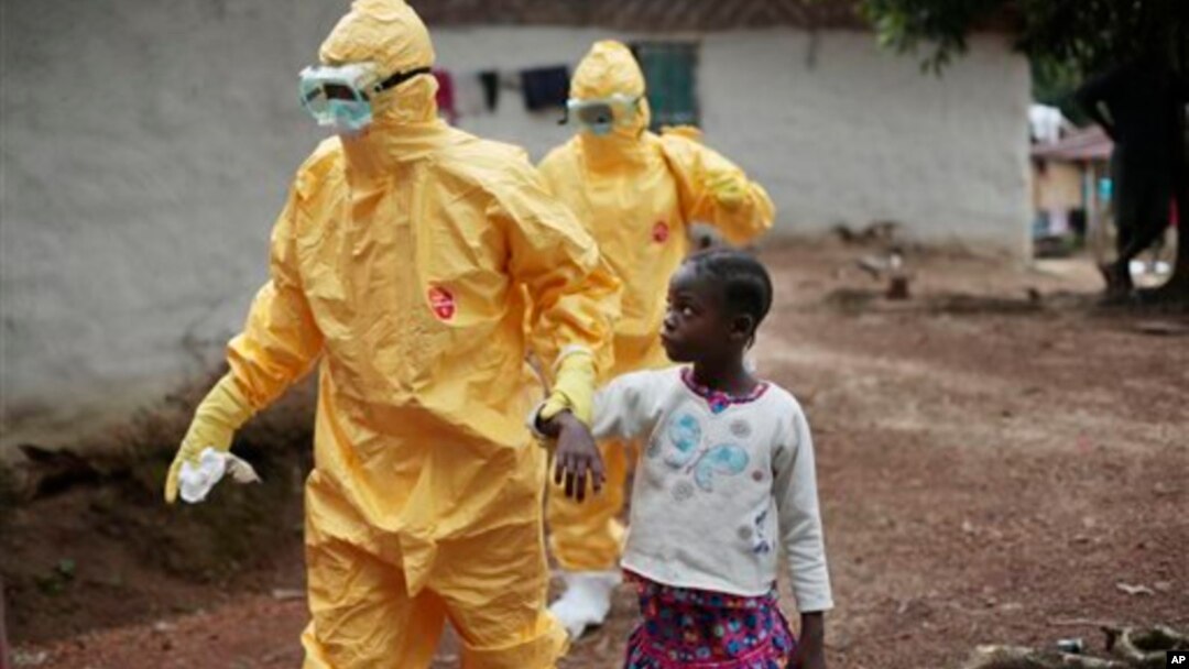 Petugas kesehatan membawa seorang anak perempuan yang menunjukkan gejala ebola di desa Freeman Reserve, Liberia (foto: dok).