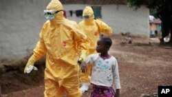 Petugas kesehatan membawa seorang anak perempuan yang menunjukkan gejala ebola di desa Freeman Reserve, Liberia (foto: dok).