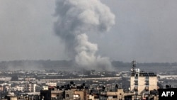 A smoke plume erupts over Khan Yunis from Rafah in the southern Gaza strip during Israeli bombardment on December 27, 2023, amid continuing battles between Israel and the Palestinian Hamas militant group.