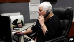 Joyce Endresen wears an Optune therapy device for brain cancer, as she speaks on a phone at work in Aurora, Illinois, March 29, 2017. She was diagnosed in December 2014 with Glioblastoma. After two surgeries to remove the tumor as well as radiation and chemotherapy Endresen is now trying the new "sci-fi" cap therapy.