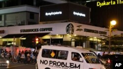 Layar elektronik di atas kafe Starbucks, lokasi serangan teroris, Kamis 14 Januari 2015, menampilkan pesan "Pray for Jakarta" untuk menunjukkan dukungan bagi warga Jakarta (Foto: AP). 