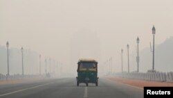 Sebuah bemo melewati jalanan di ibukota New Delhi, India, yang berselimut kabut asap akibat polusi, 11 November 2019. REUTERS/Adnan Abidi - RC2V8D91UTBI