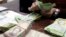 FILE - A cashier counts bolivars at a money exchange in Caracas, Venezuela, Feb. 24, 2015. 