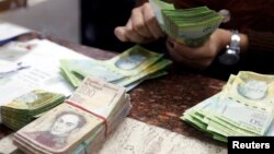 A cashier counts bolivars at a money exchange in Caracas, Venezuela, Feb. 24, 2015. 