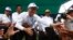 Sam Rainsy, center, president of the Cambodia National Rescue Party, shakes hands with his party supporters during an election campaign at Kampong Speu province, west of Phnom Penh, July 20, 2013. 