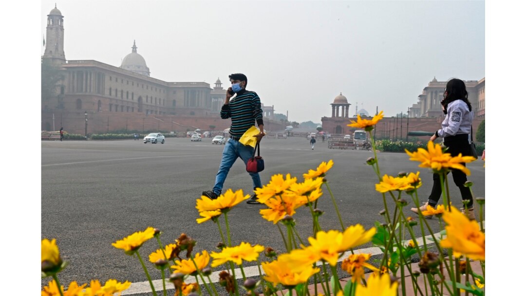 A pedestrian wearing a face mask as a preventive measure against the COVID-19 coronavirus walks through a road in New Delhi on Jan. 9, 2021.