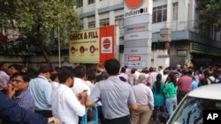 People stand outdoors after they rushed pout of their offices following tremors in Kolkata, India, Aug. 24, 2016. 