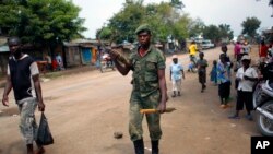 FILE- In this Aug. 5, 2012 file photo, an M23 rebel walks the streets of the North Kivu town of Rubare near Rutshuru, 75 km (48 miles) north of Goma, Congo. 