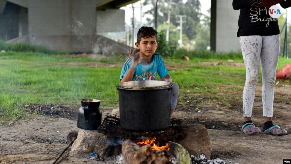 Un niño saludó a la cámara, sentado junto a la fogata donde se cocinaron los alimentos. [Foto: Diego Huertas]