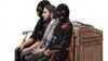 In this courtroom sketch, Salah Abdeslam, center, sits between two police officers during his trial at the Brussels Justice Palace in Brussels, Belgium, Feb. 5, 2018.