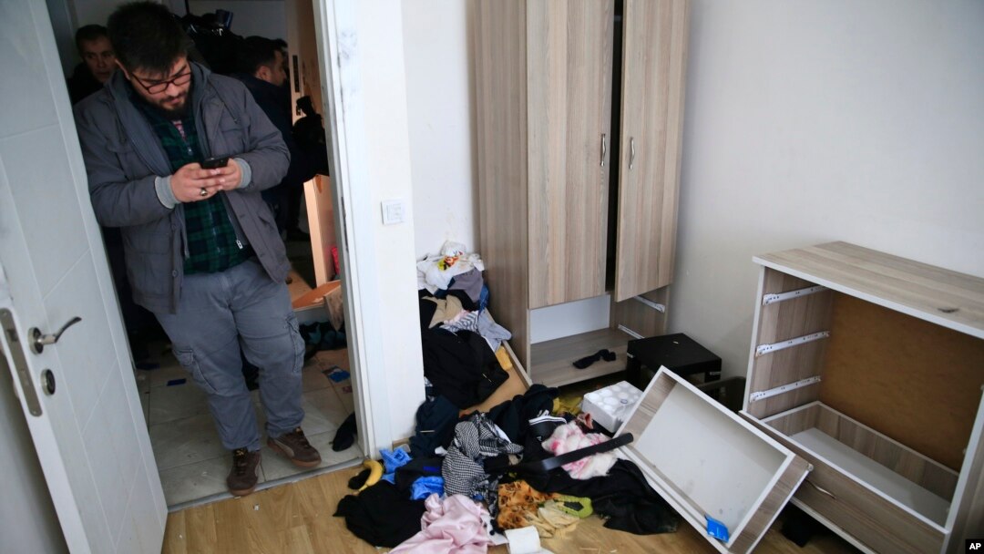 Polisi berpakaian preman di dalam apartemen tempat tinggal tersangka pembantaian kelab malam dalam razia di Istanbul (17/1). (AP/Lefteris Pitarakis)