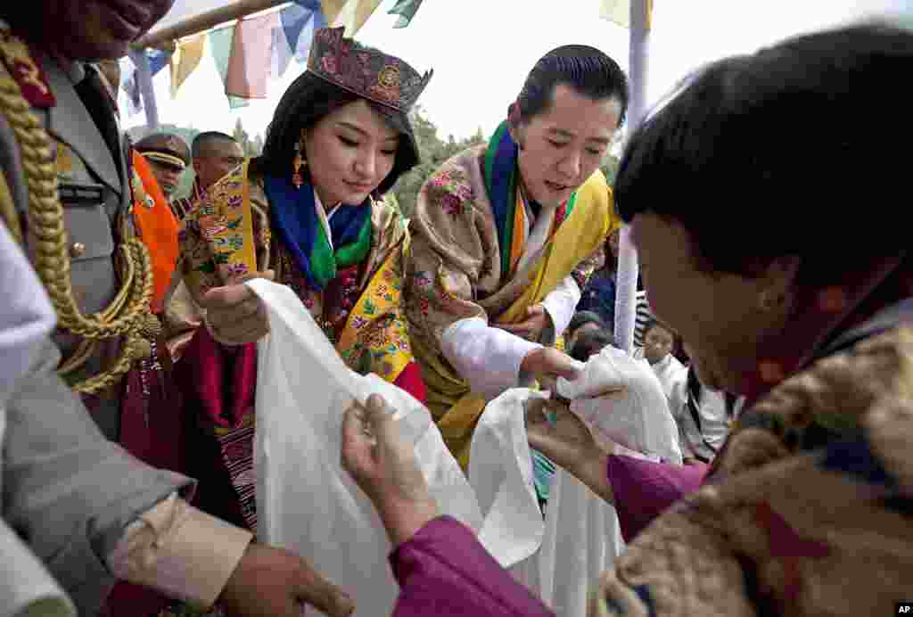 King Jigme Khesar Namgyel Wangchuck and Queen Jetsun Pema are given scarves by locals during a celebration after they were married. (AP)