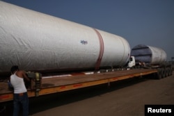 Windmill tubes of Adani Green Energy are loaded on transport trucks along Ahmedabad-Mundra National Highway near Viramgam in the western state of Gujarat, India, Nov. 25, 2024.