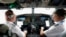 FILE - American Airlines pilot captain Pete Gamble, left, and first officer John Konstanzer conduct a pre-flight check before taking off from Dallas Fort Worth airport on Dec. 2, 2020, in Grapevine, Texas.