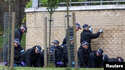 Tim forensik polisi Inggris memeriksa barang bukti di Woolwich, London selatan sehari setelah serangan atas seorang tentara Inggris (23/5). 