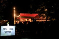 A line of people stand at the ticket area as they wait to enter Terror Town, Oct. 17, 2020, in Williamsburg, Ohio.