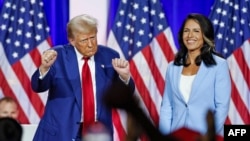 FILE - U.S. President Donald Trump dances as he leaves the stage alongside former U.S. Representative Tulsi Gabbard during a town hall in La Crosse, Wisconsin, on Aug. 29, 2024. The Senate on Feb. 12, 2025, approved Gabbard's nomination to be director of national intelligence.