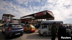 FILE - Cars stand in line at a gasoline station as they wait to fuel up in Aleppo, Syria, April 11, 2019.