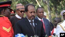 Somalia's President Hassan Sheikh Mohamud, center, lays a wreath as Kenya's President Uhuru Kenyatta, center right, and President Muhammadu Buhari of Nigeria, center left, stand behind at an interfaith memorial service honoring Kenyan soldiers killed whil