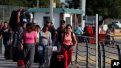 Para pekerja asal Meksiko melintasi penyeberangan internasional Puerta Mexico menuju Brownsville, Texas di Amerika Serikat, untuk mencari pekerjaan musiman, di Matamoros, negara bagian Tamaulipas, Meksiko, 27 Juni 2020. 